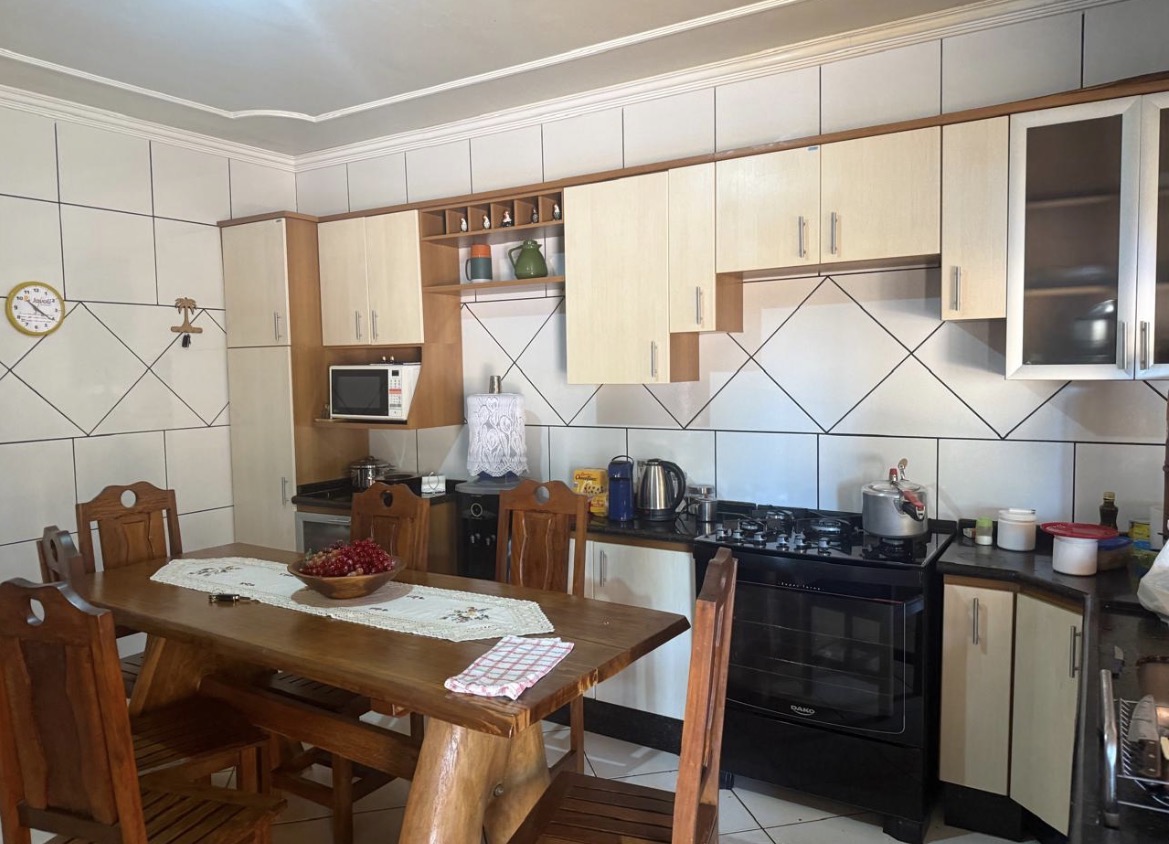Cozinha antes do projeto: bancada de trabalho, armário de vidro e fogão preto