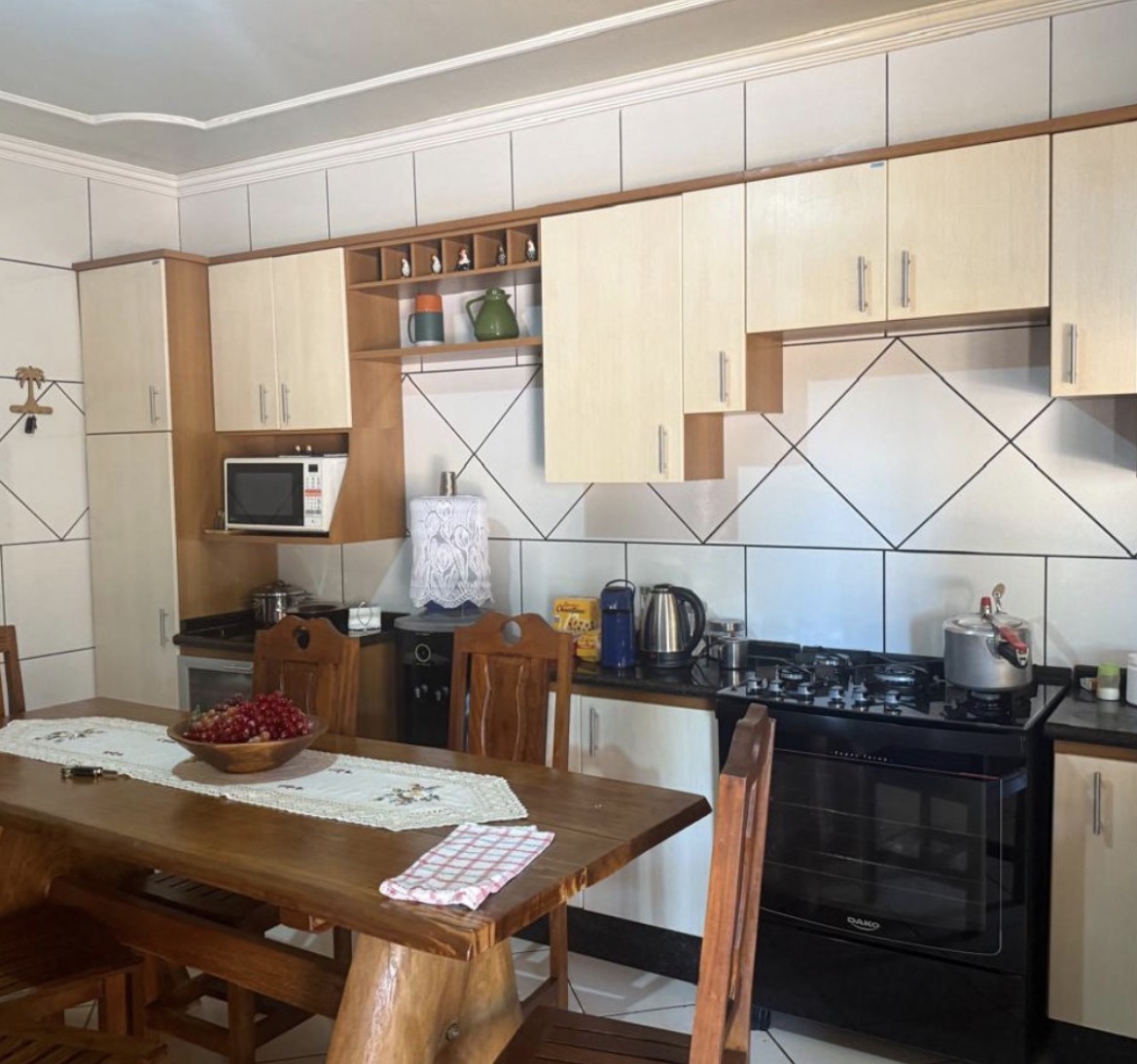 Cozinha antes do projeto: mesa de madeira rústica e área de refeições
