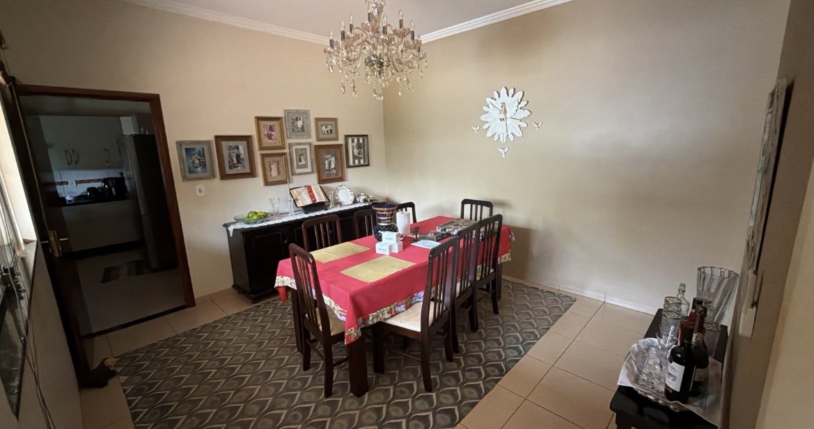 Sala de jantar antes do projeto: mesa de madeira escura com toalha vermelha